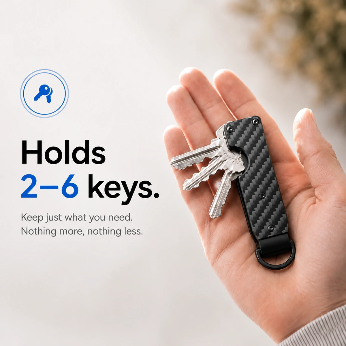 Carbon Weave compact tracking key organizer holding several keys in a palm #color_Carbon Weave