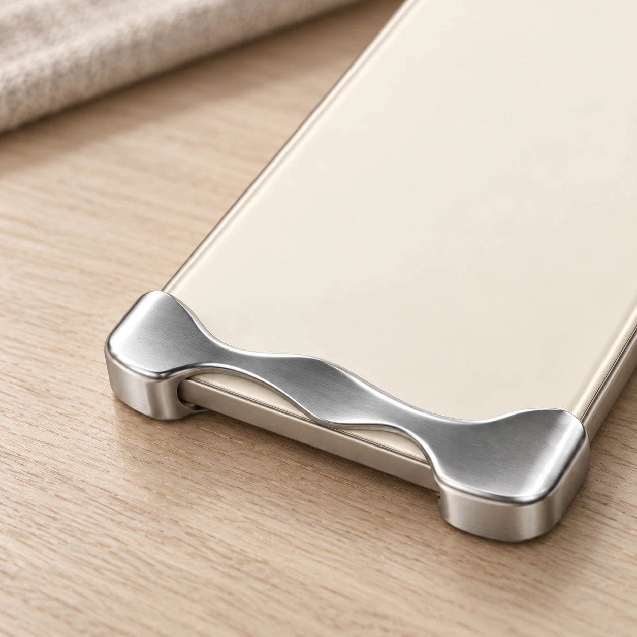 Close-up of the curved silver lower guard and exposed edge on a cream phone.